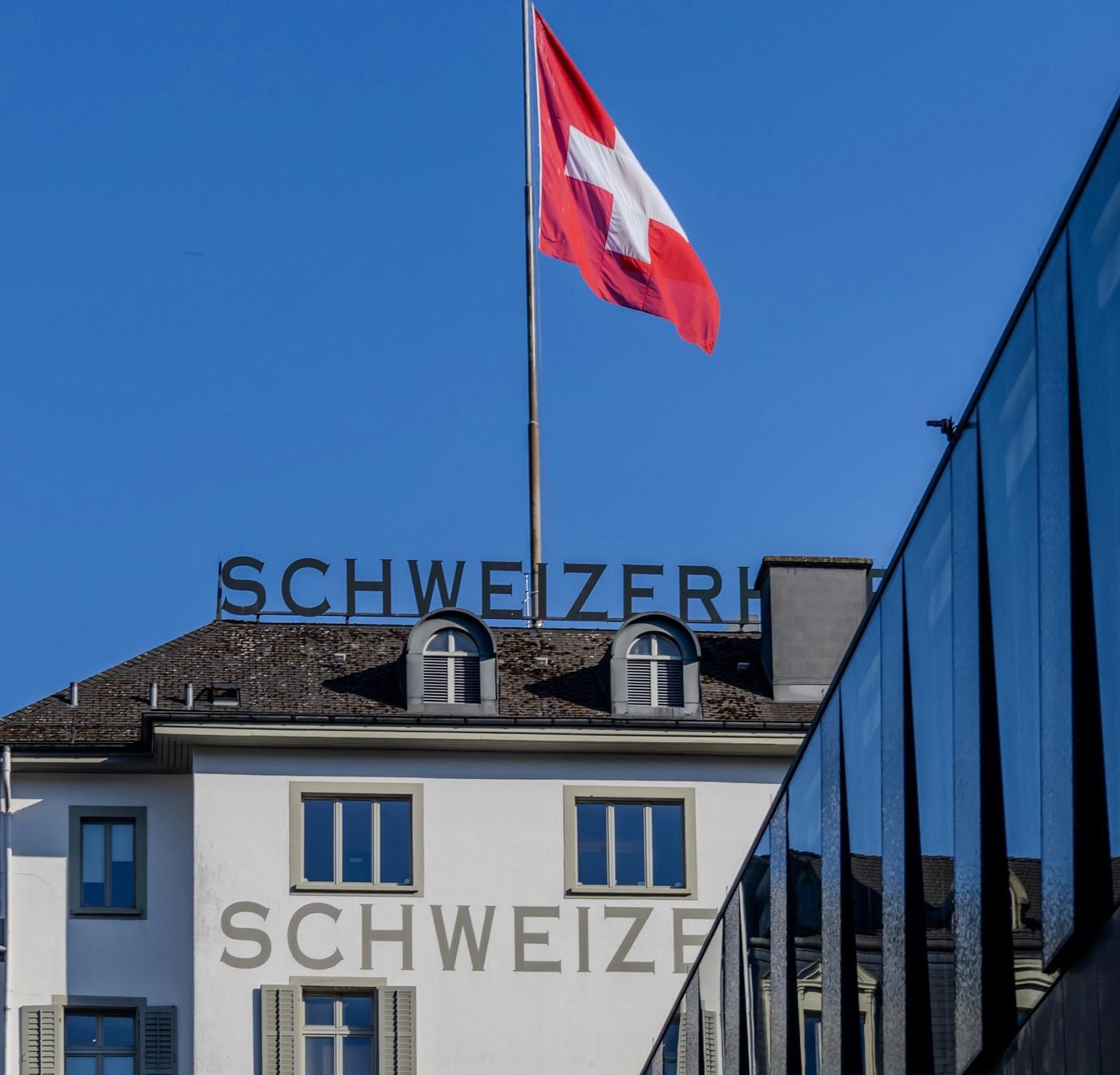 Drapeau suisse sur un batiment, illustrant la prime d assurance maladie LAMal en Suisse