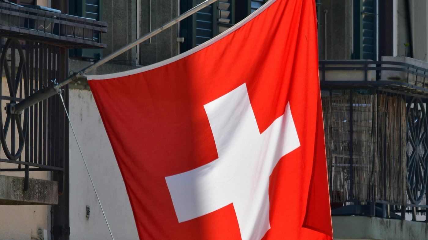 Drapeau suisse sur le balcon d'un immeuble d'habitation en Suisse romande