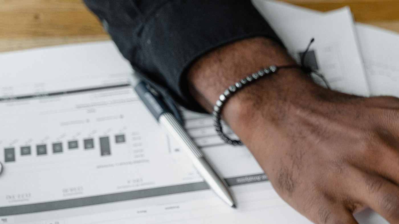 Main tenant un stylo sur un contrat de travail, signature d'un CDI en Suisse