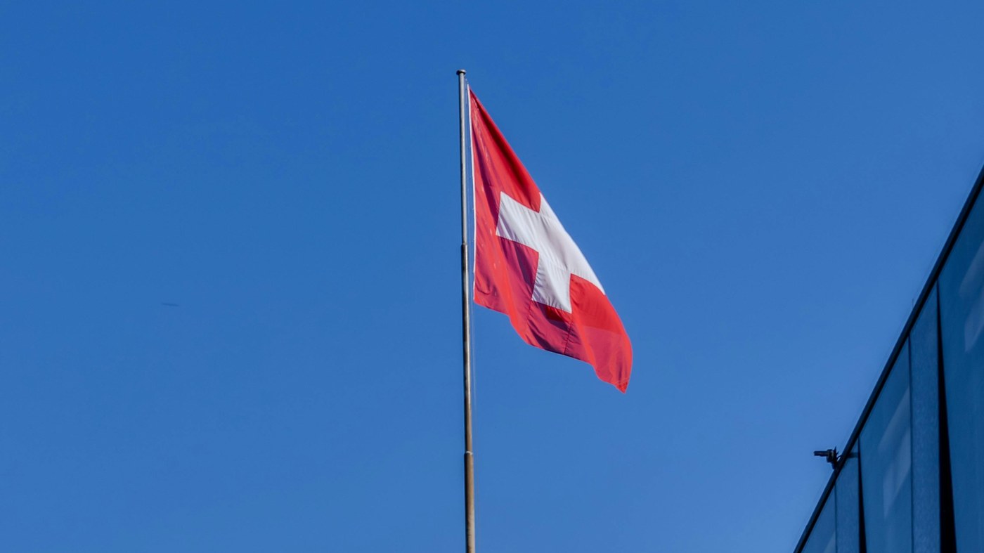 Drapeau suisse sur un toit, quel site pour travailler en Suisse