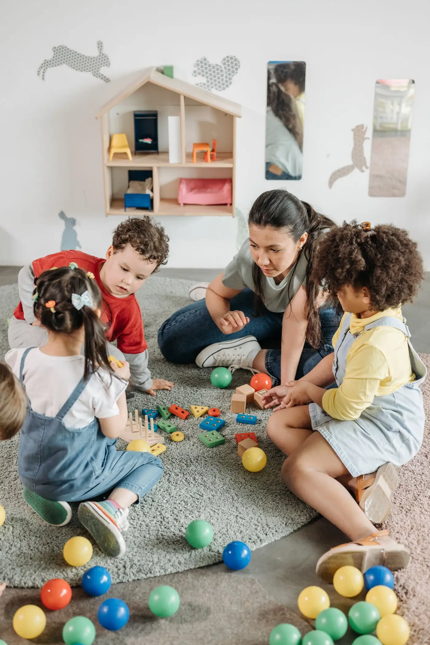 educatrice de la petite enfance qui joue au sol avec des tout-petits en Suisse